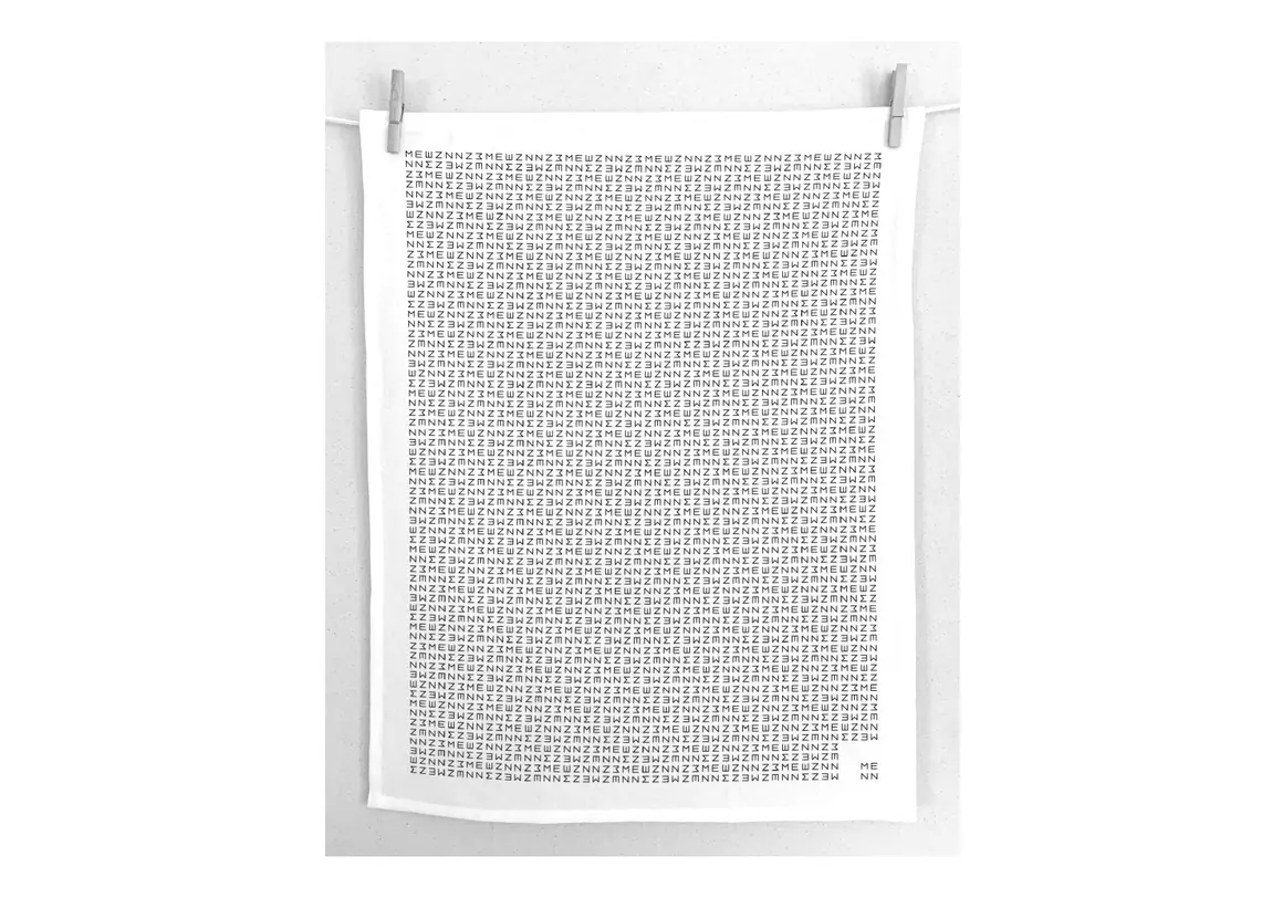 Menn tea towel printed with the repeating marque