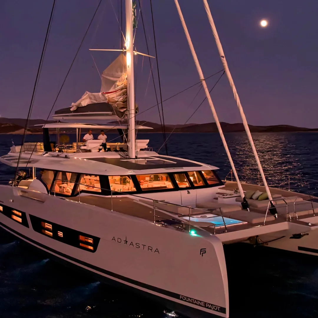 Odyssea Yachting catamaran at anchor under moonlight